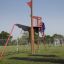 Kind spielend auf einem Mast Klettergerüst mit Netz und Rutsche auf einem Spielplatz.