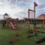 Mast Klettergerüst auf einem Spielplatz mit Rutschen und Kletterseilen
