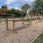 Kinder-Klettergerüst Mast auf Spielplatz mit Rutschen und Kletternetzen.