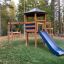 Spielturm mit Klappbrücke und Rutsche im Freien