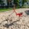 Sand Bagger Spielgerät aus Metall mit rotem Sitz und Hebel für Sandbagger-Aktivitäten auf dem Spielp