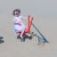 Kind spielt mit rotem Sand Bagger auf dem Spielplatz im Sand.