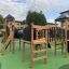 Spielturm mit Tunnel, Rutsche und Kletterwand auf einem Spielplatz