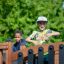 Kinder spielen auf einem Spielturm mit Tunnel und Rutsche im Park.