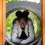 Mädchen lächelt in einem Spielturm mit Tunnel.