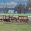 Kleine Fitnessanlage mit verschiedenen Holzelementen und Bänken im Freien auf einem Sportplatz