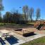 Spielturm mit Rutsche und Sandkasten auf einem sonnigen Spielplatz