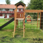 Kletterturm mit Rutsche und Kletternetz im Garten.