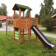 Kletterturm mit Rutsche und Leiter im Garten, spezielles Design mit grünen Verzierungen.