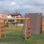 Horizontale Leiter Robinie auf einem Spielplatz mit grünem Gras und Hintergrundbebauung.