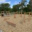 Horizontale Leiter Robinie auf einem Kinderspielplatz mit Kletternetzen und Rutschen.