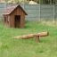 Natur Spielhaus aus Holz mit Balancierstamm im Garten