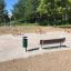 Outdoor-Fitnessbereich mit HPL-Bänken und Trainingsgeräten im Park.