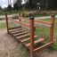 Bewegliche Brücke aus Holz mit Ketten auf einem Kinderspielplatz in natürlicher Umgebung.