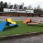 Bunte Sofa Lounge auf grünem Rasen in öffentlicher Parkanlage.