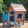 Holzspielhaus Olles Spielhaus mit Rutsche für Kinder auf einem Spielplatz.
