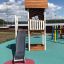 Lisas Spielturm mit Rutsche auf einem bunten Spielplatz